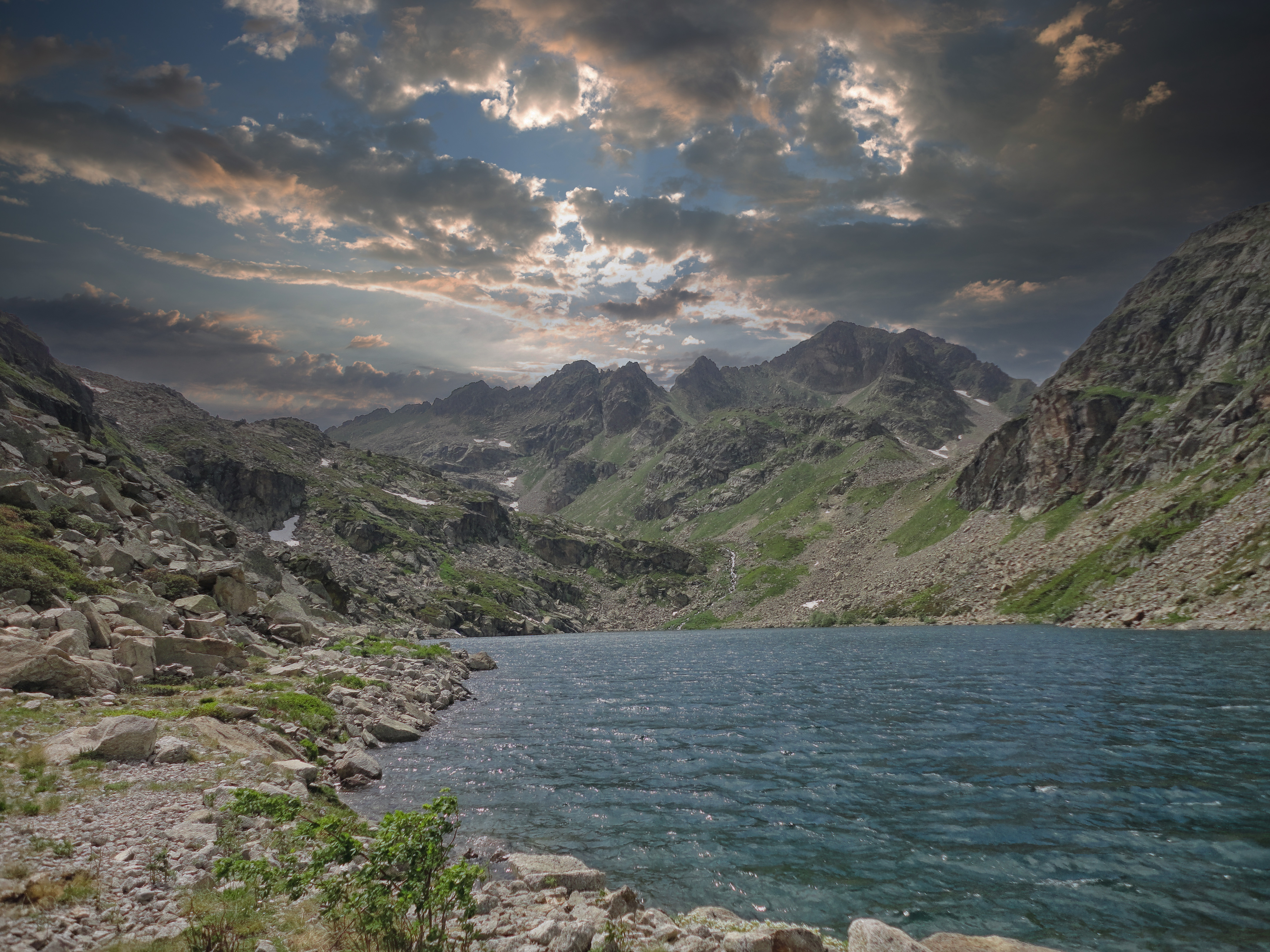 L'Étang du Couart et les crêtes du Pic du Rulhe sous un ciel d'orage